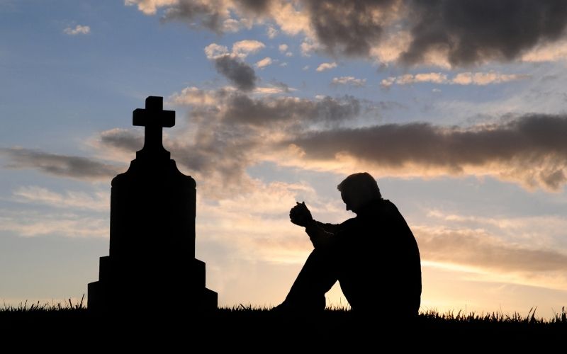 A man who is graveyard and thinking about death