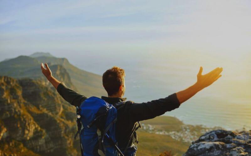 Man has opened his arms in the mountain after successful shifting 