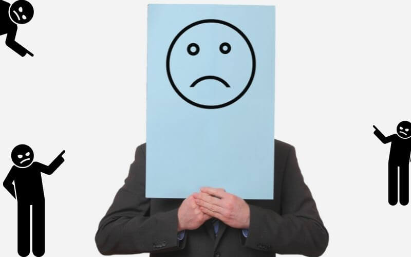 A man holding a paper with a negative smiley on a white background