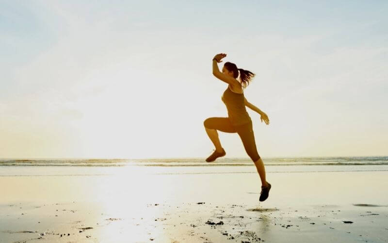 Photo of a beautiful young woman and athlete training on the beach