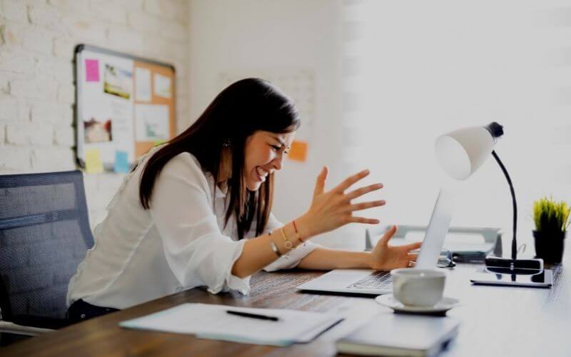 Side view of a frustrated young businessman looking at a laptop in the office