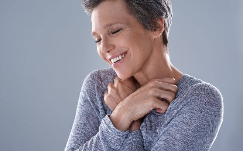 Studio shot of an attractive mature woman posing against a gray background