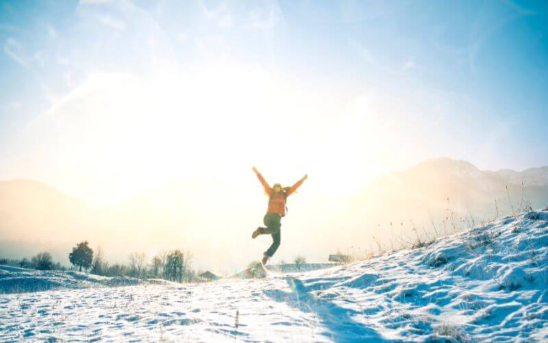 An adult woman having fun and being playful during winter outdoors