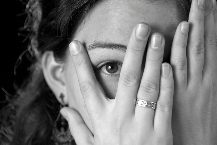 A woman covering her eyes because of being afraid of Teraphobia