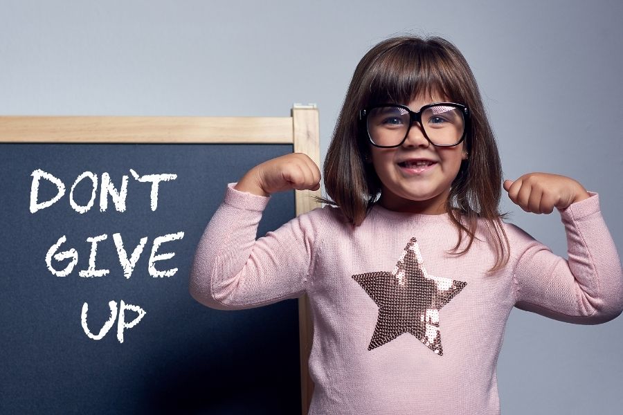 A happy girl with the word dont give up on the blackboard 