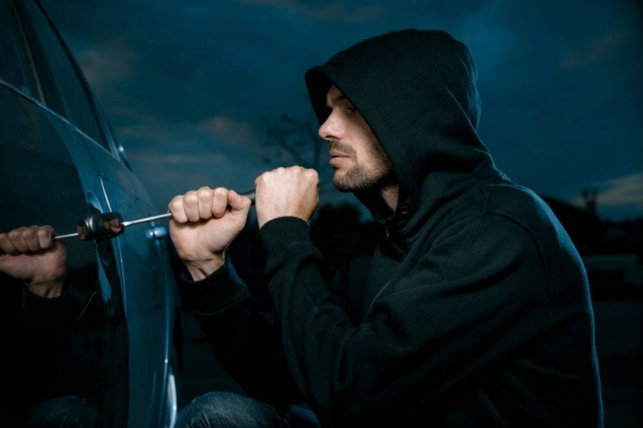 A thief is stealing a car 