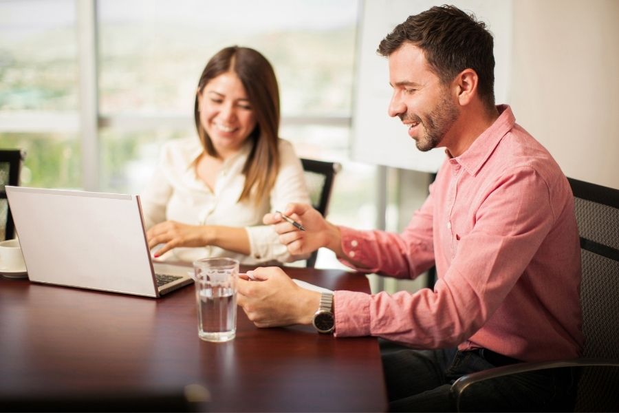 a young man and a cute woman having fun time while working in the office