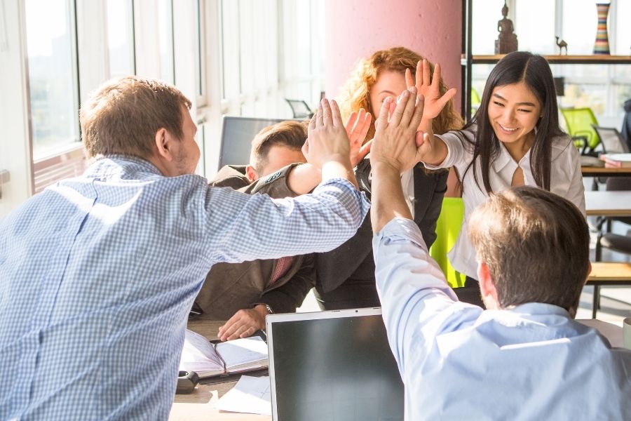 business people showing team work and giving five