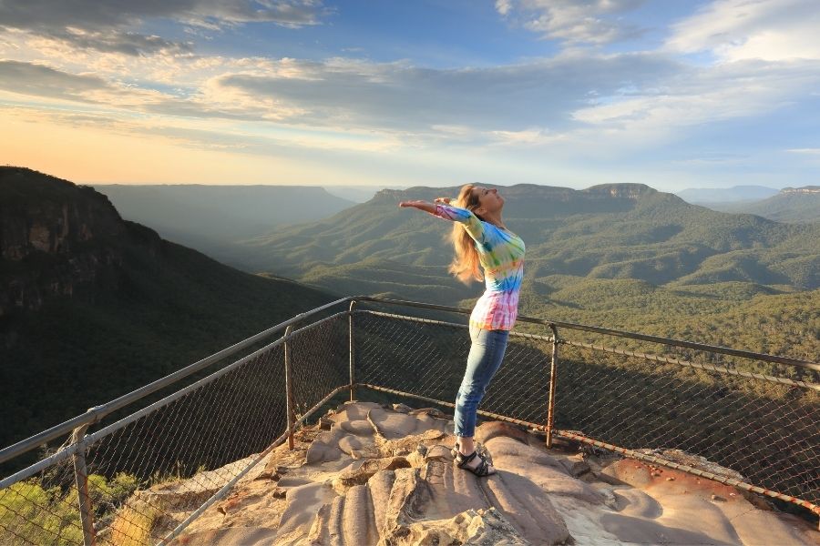 A happy and possitive woman at the top of mountain 