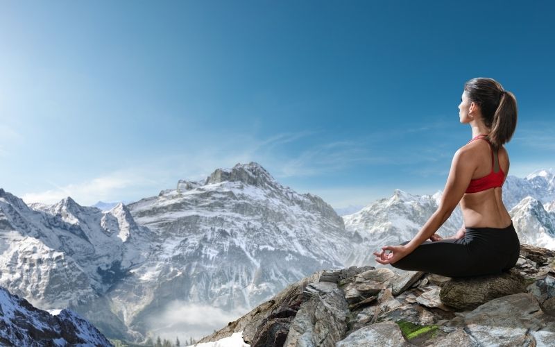 A woman meditating on a rock