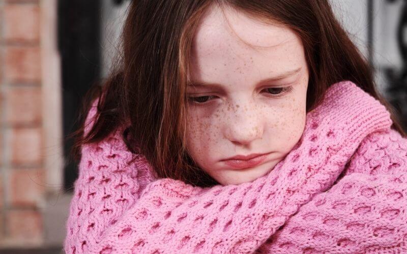 Sad little girl in a pink dress