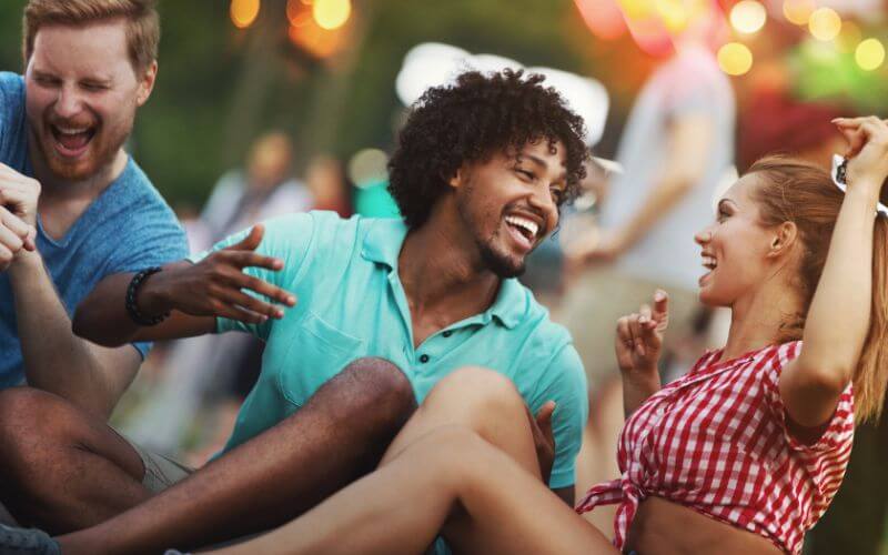 Closeup of group of multi ethnic young adults having fun and enjoying summer evening outdoors