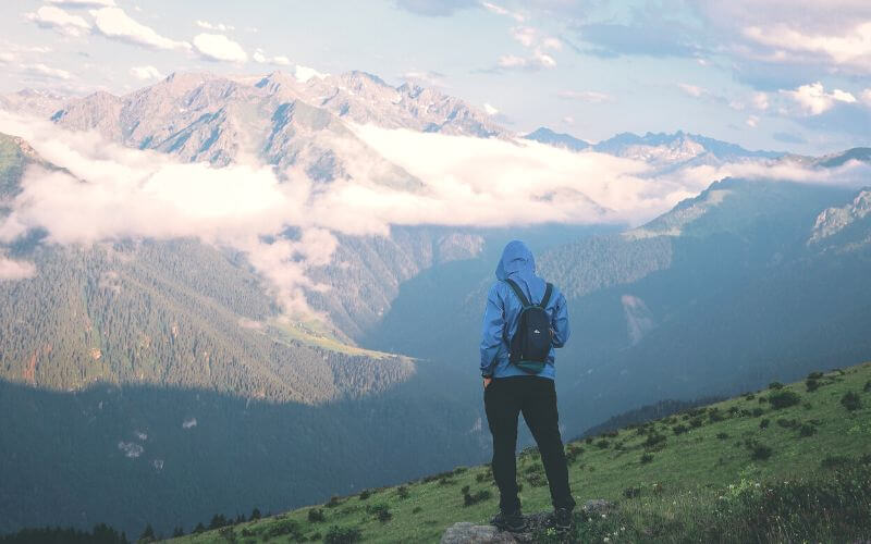Unrecognizable traveler admiring mountainous landscape
