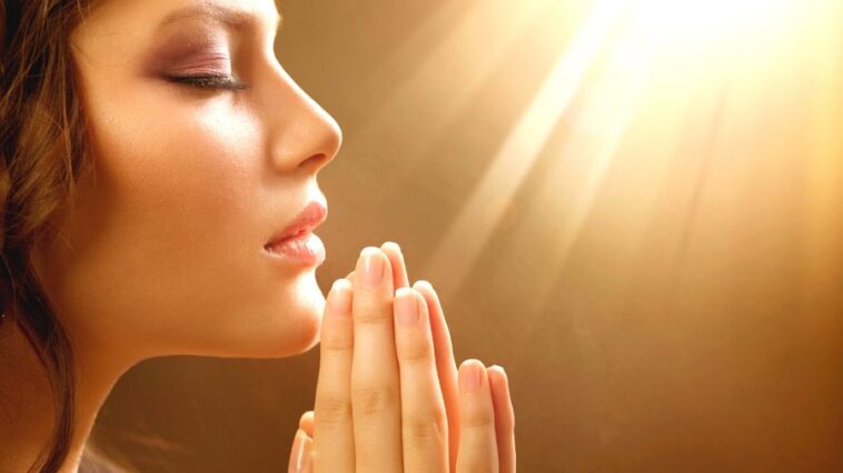 A woman praying to the god and asking Is Manifesting A Sin