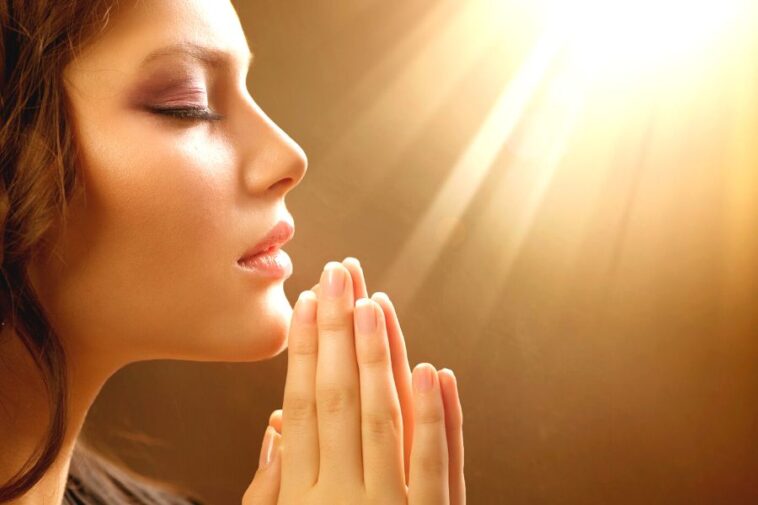 A woman praying to the god and asking Is Manifesting A Sin